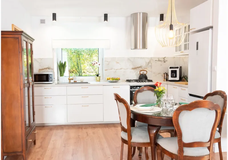 stylowe wnętrze apartamentu z widokiem na aneks kuchenny oraz stół jadalny