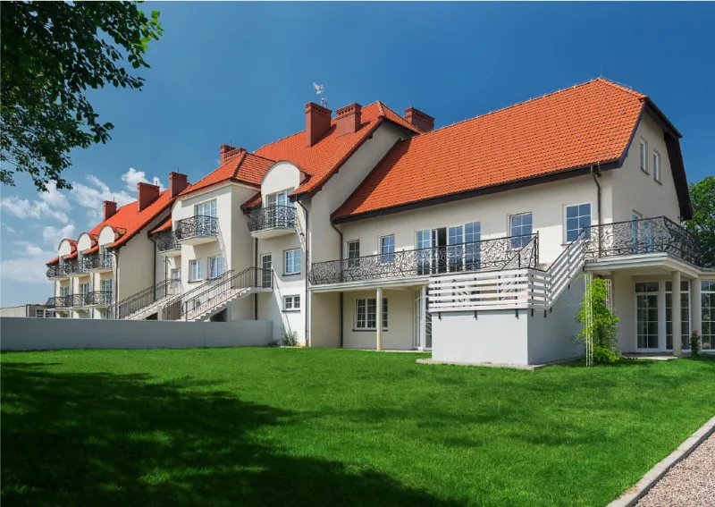 widok dużego białego budynku i zielonego trawnika przed nim