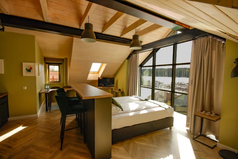 wnętrze apartamentu z widokiem na łóżko oraz okno z widokiem na port