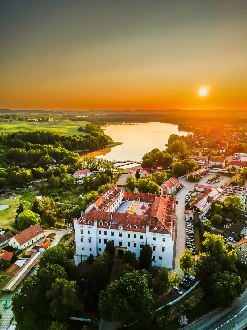 Hotel na tle miasteczka, zieleni i jeziora