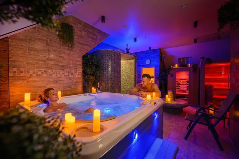 Zdjęcie wnętrza sauny, pani w jacuzzi, palące się świece