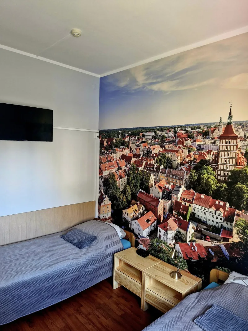 pokój z dwoma łóżkami i fototapetą ze zdjęciem miasta Olsztyna